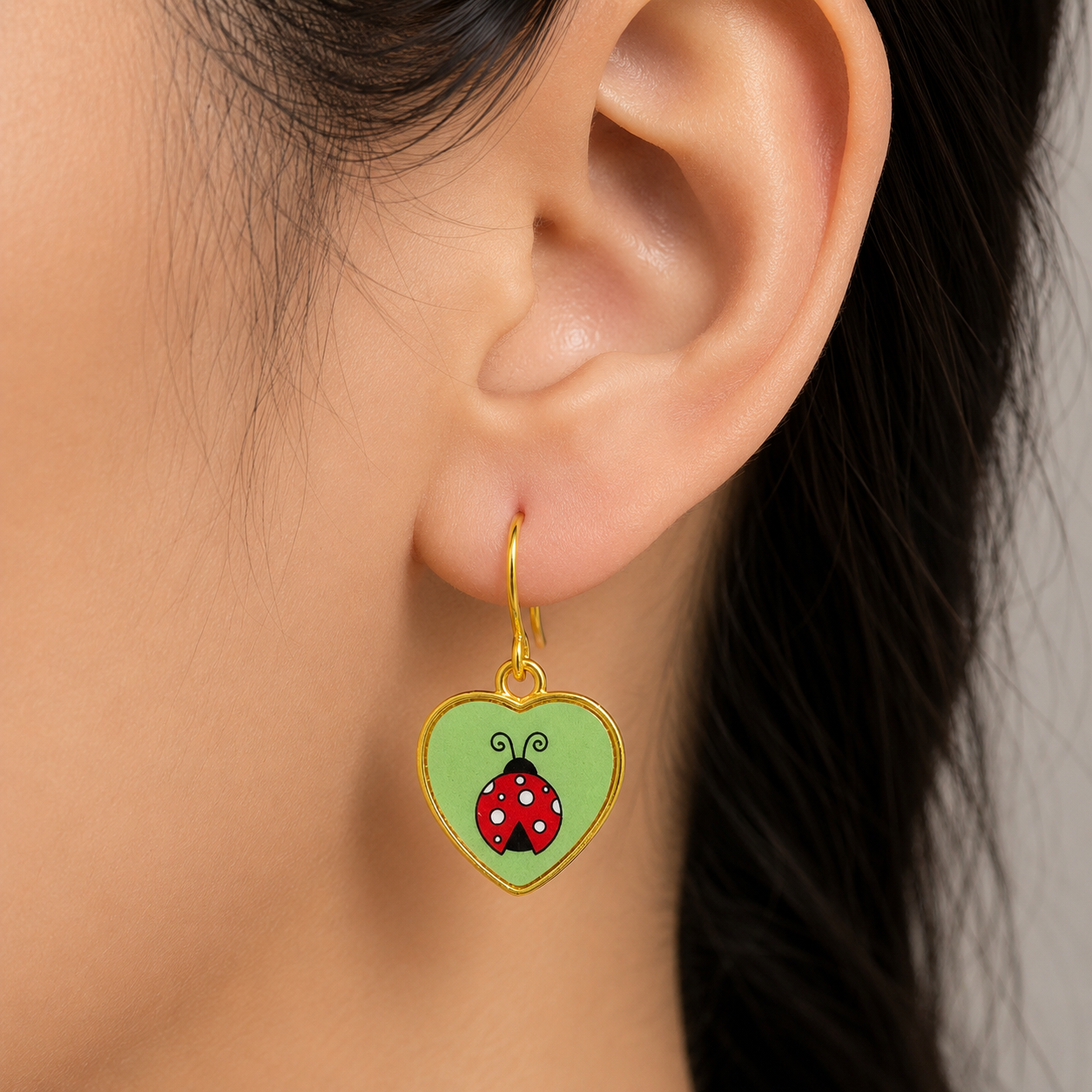 Dangling heart-shaped earring with ladybug