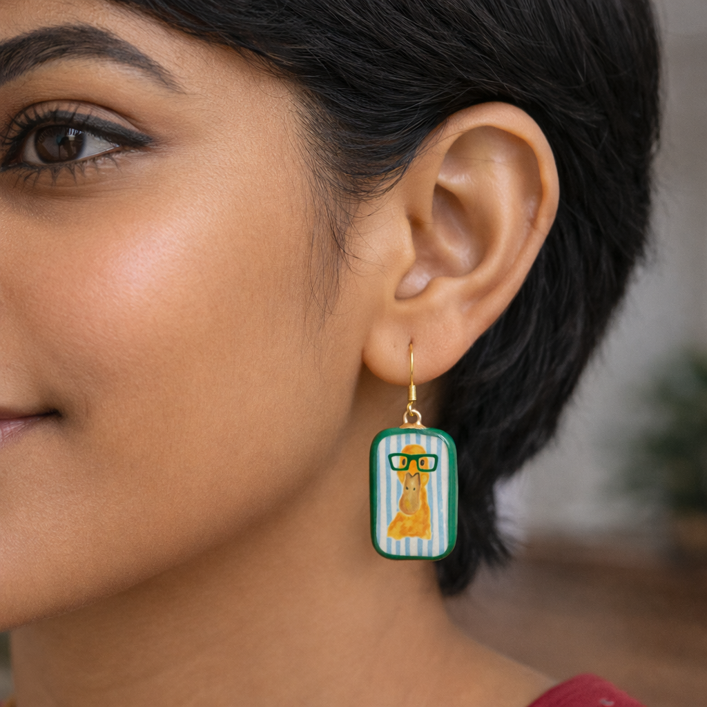 Close-up of a woman wearing earrings with a giraffe design.